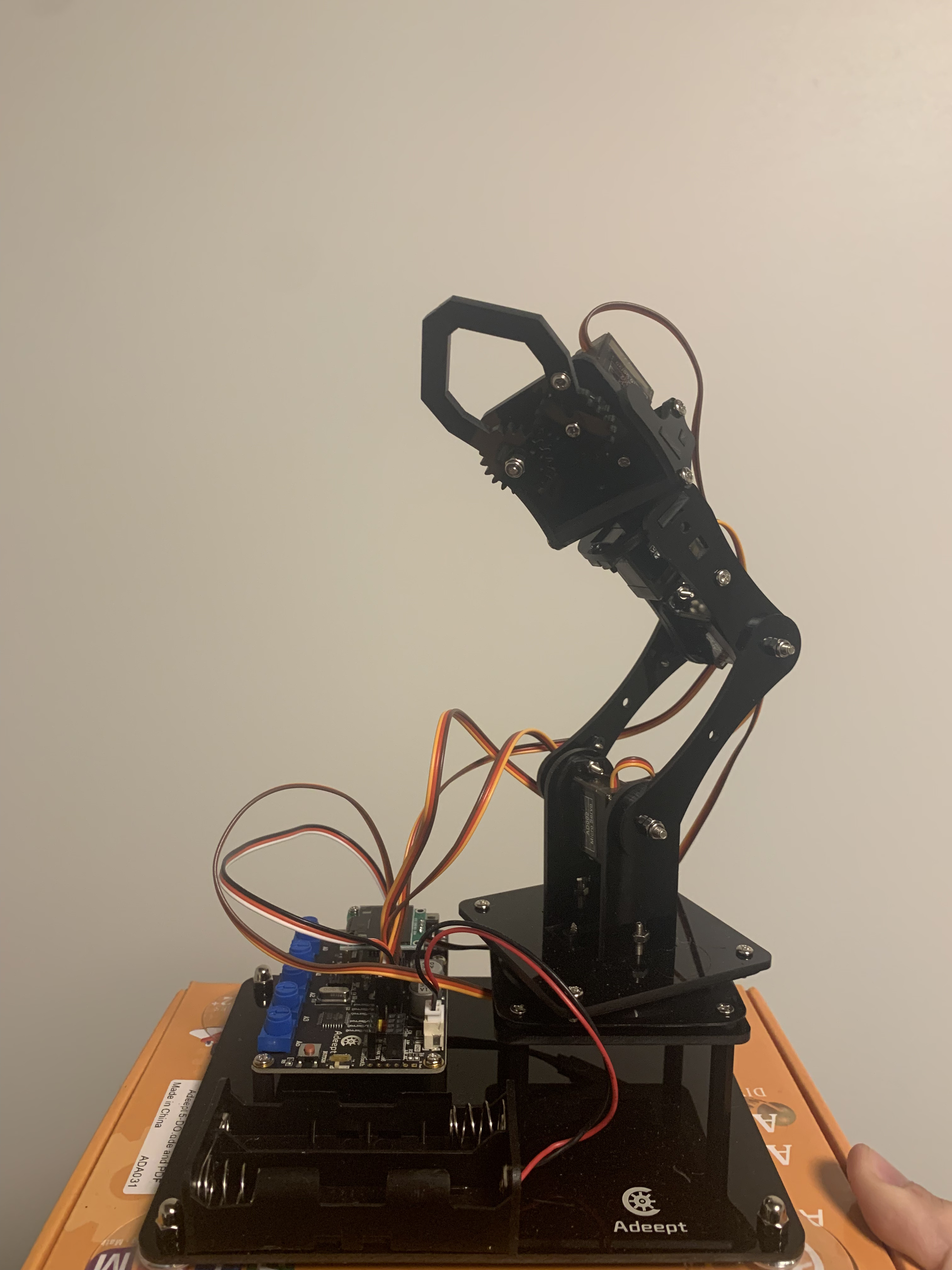 CruX brain-controlled pincher robotic arm with control electronics, showing the physical implementation of the brain-computer interface system