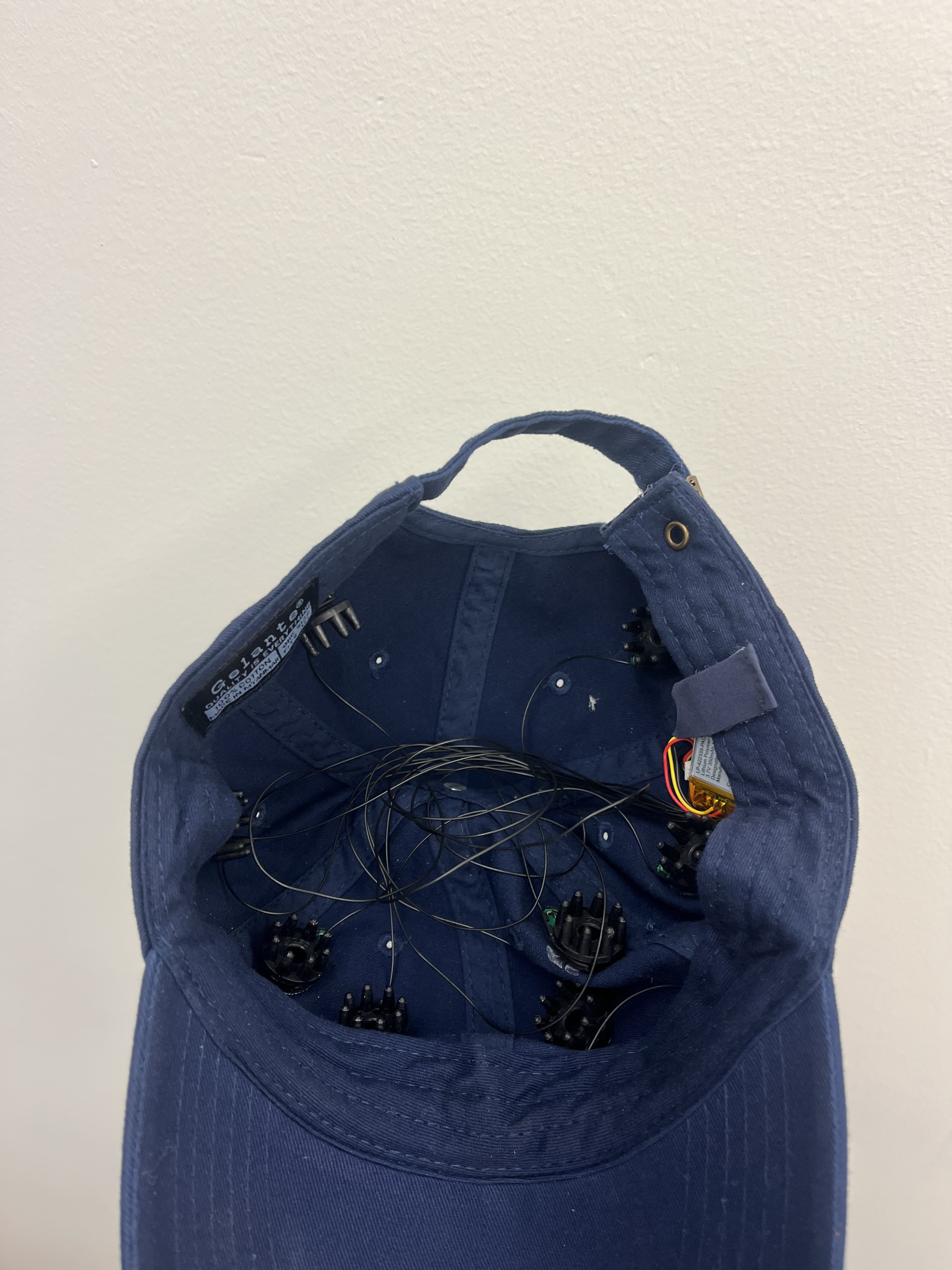 Interior view of baseball cap showing integrated EEG electrodes and wiring system