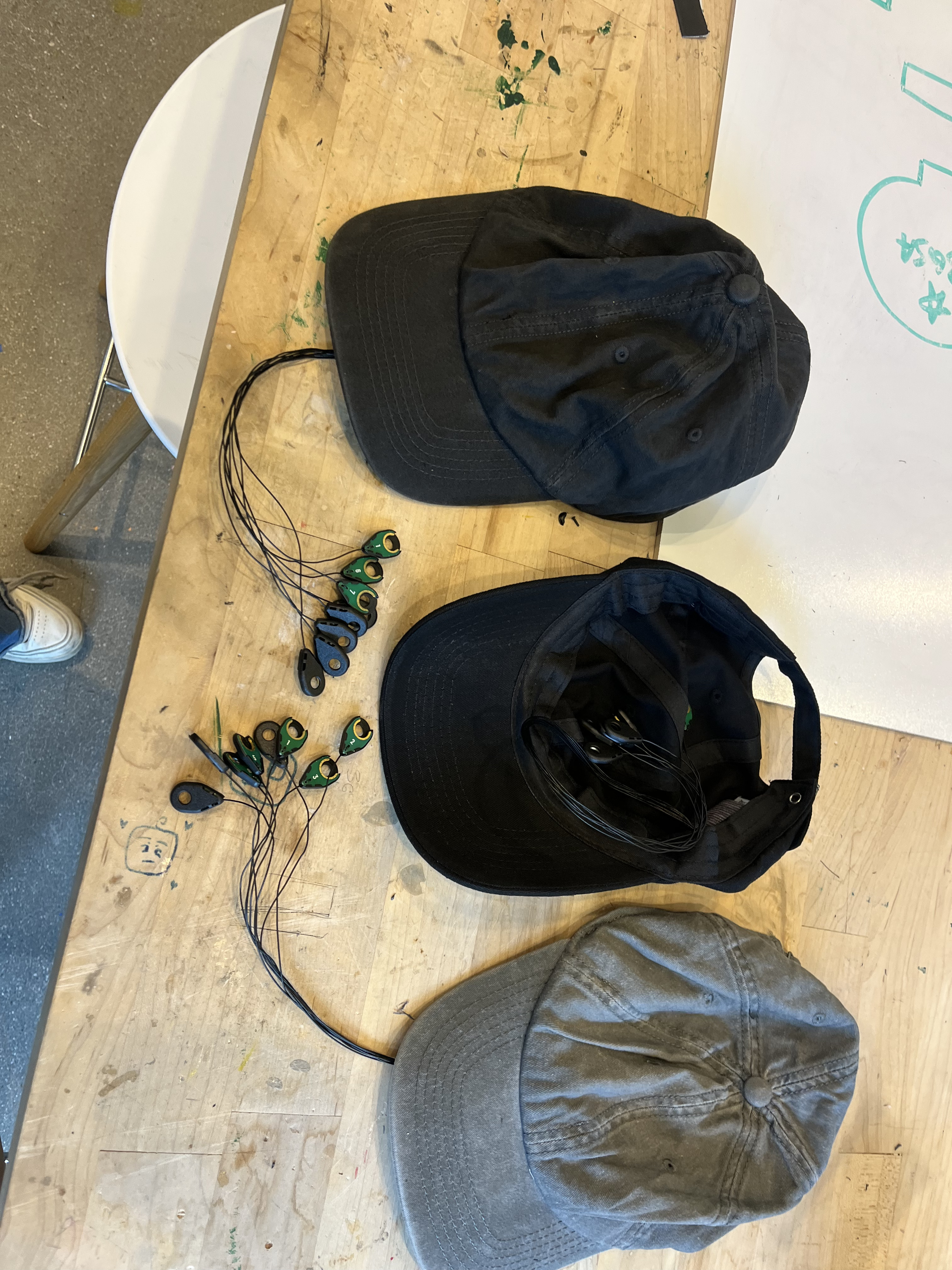 Multiple discrete EEG baseball caps showing manufacturing and assembly process
