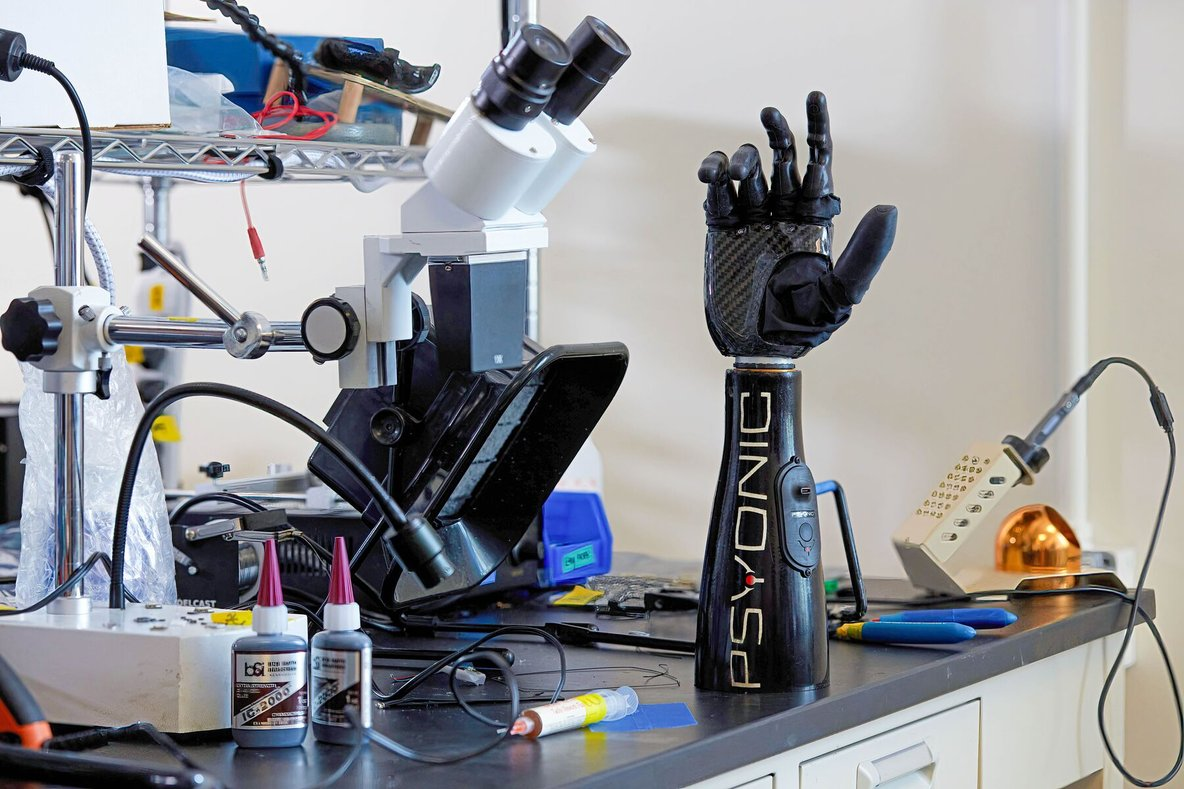 Psyonic laboratory setup showing prosthetic hand testing environment with microscope and various tools
