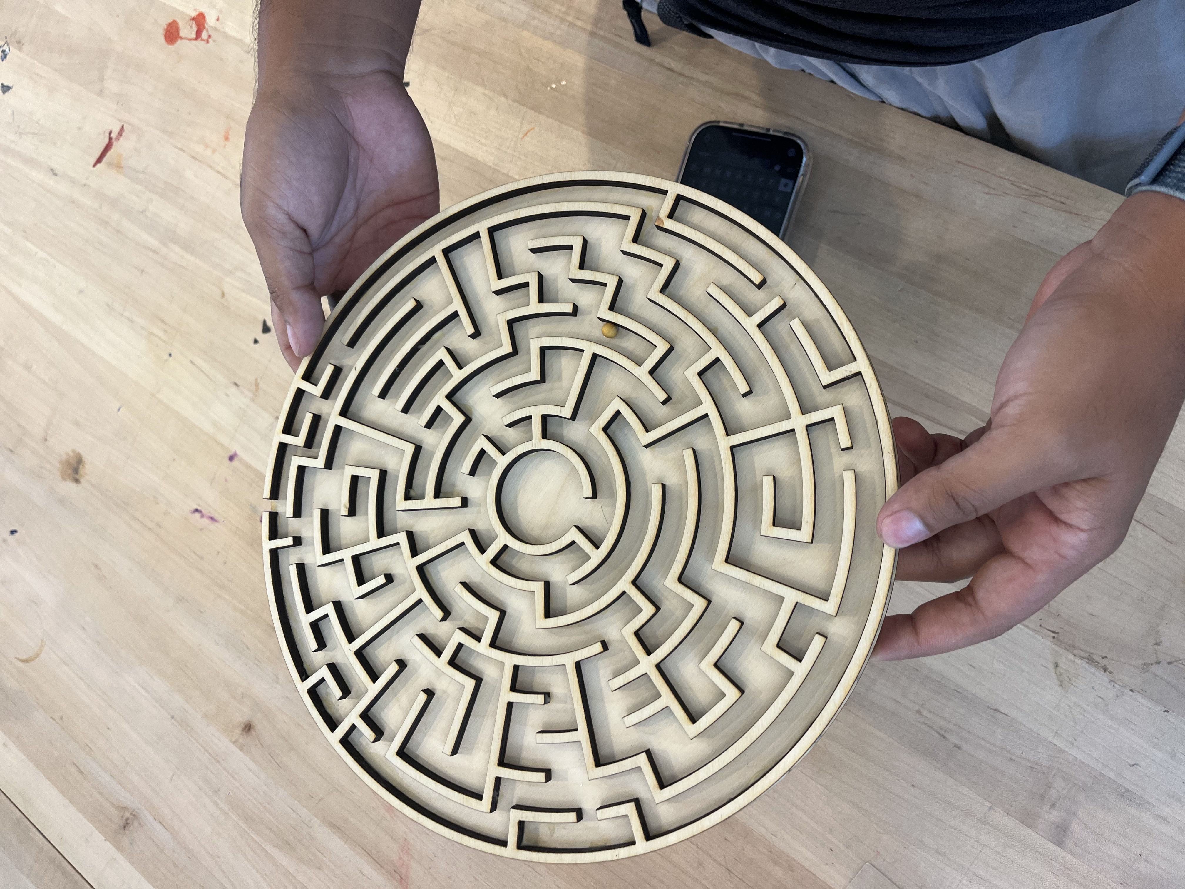 Circular wooden maze with intricate laser-cut pathways